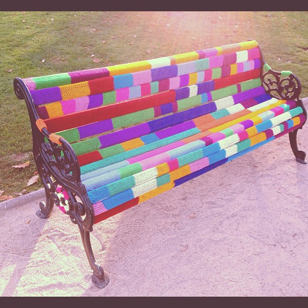 park bench that is covered in knitting